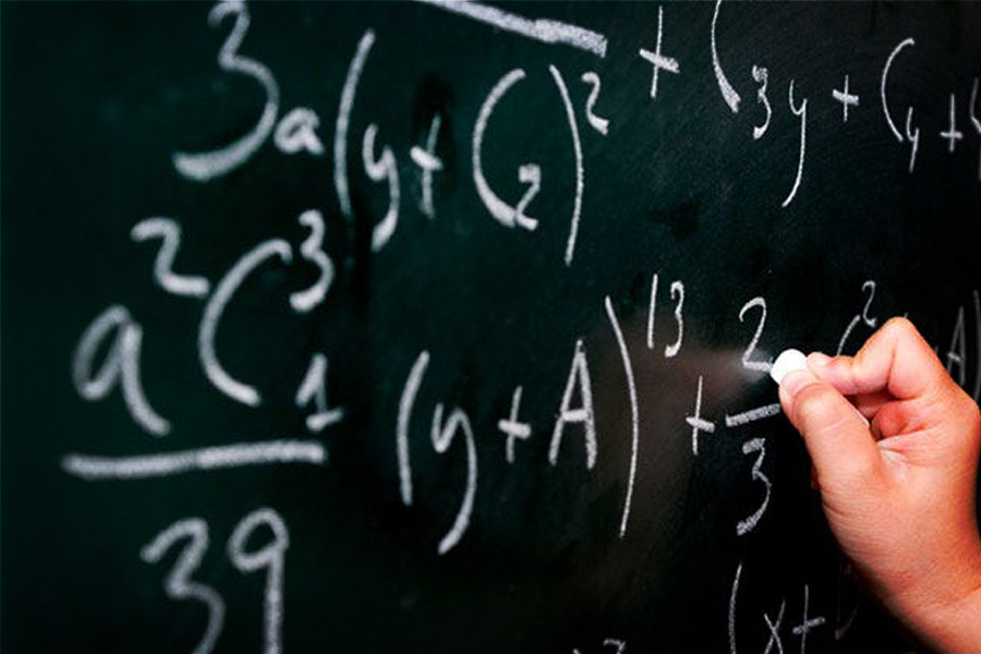 Child making mathematical calculations on a chalkboard with chalk